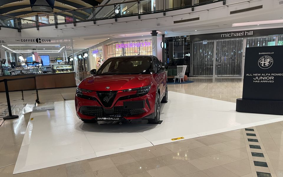 Red SUV on a white gloss display floor in a car showroom