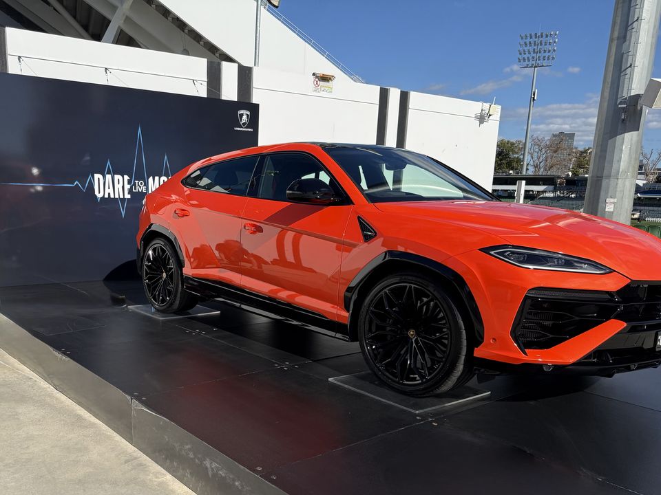 Orange SUV on a black display platform in front of a dark backdrop