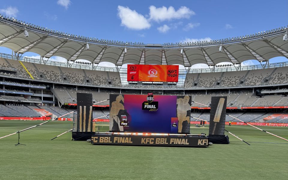 Rolling presentation stage with a branded backdrop on a stadium field